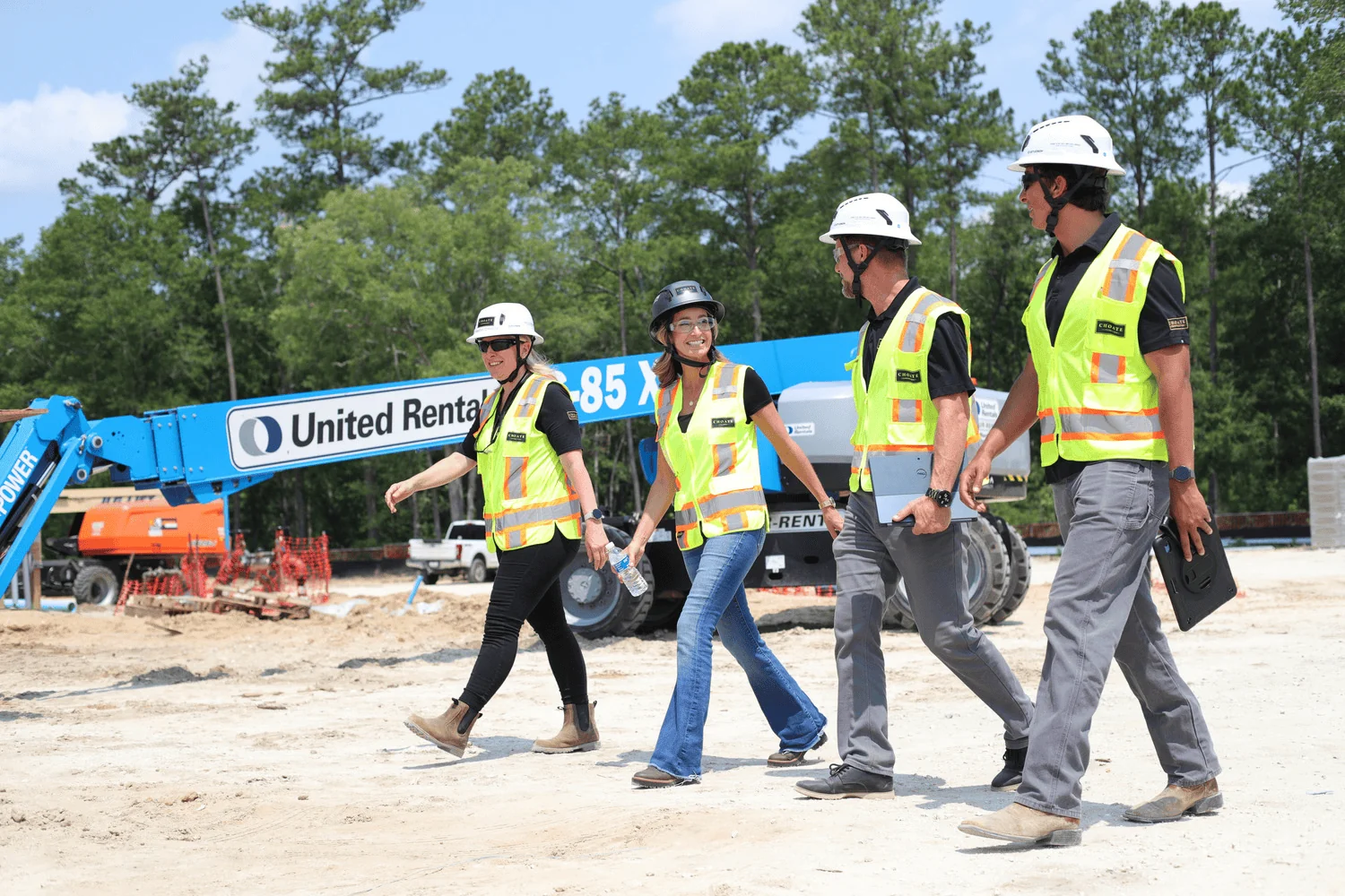 Four Choate Construction team members walking together across an active jobsite.
