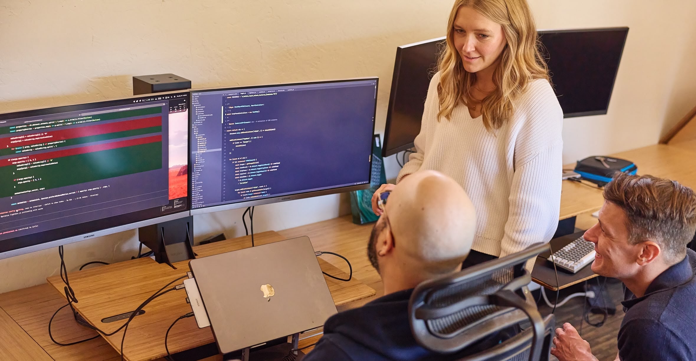 Photo of two people collaborating at a table with a laptop