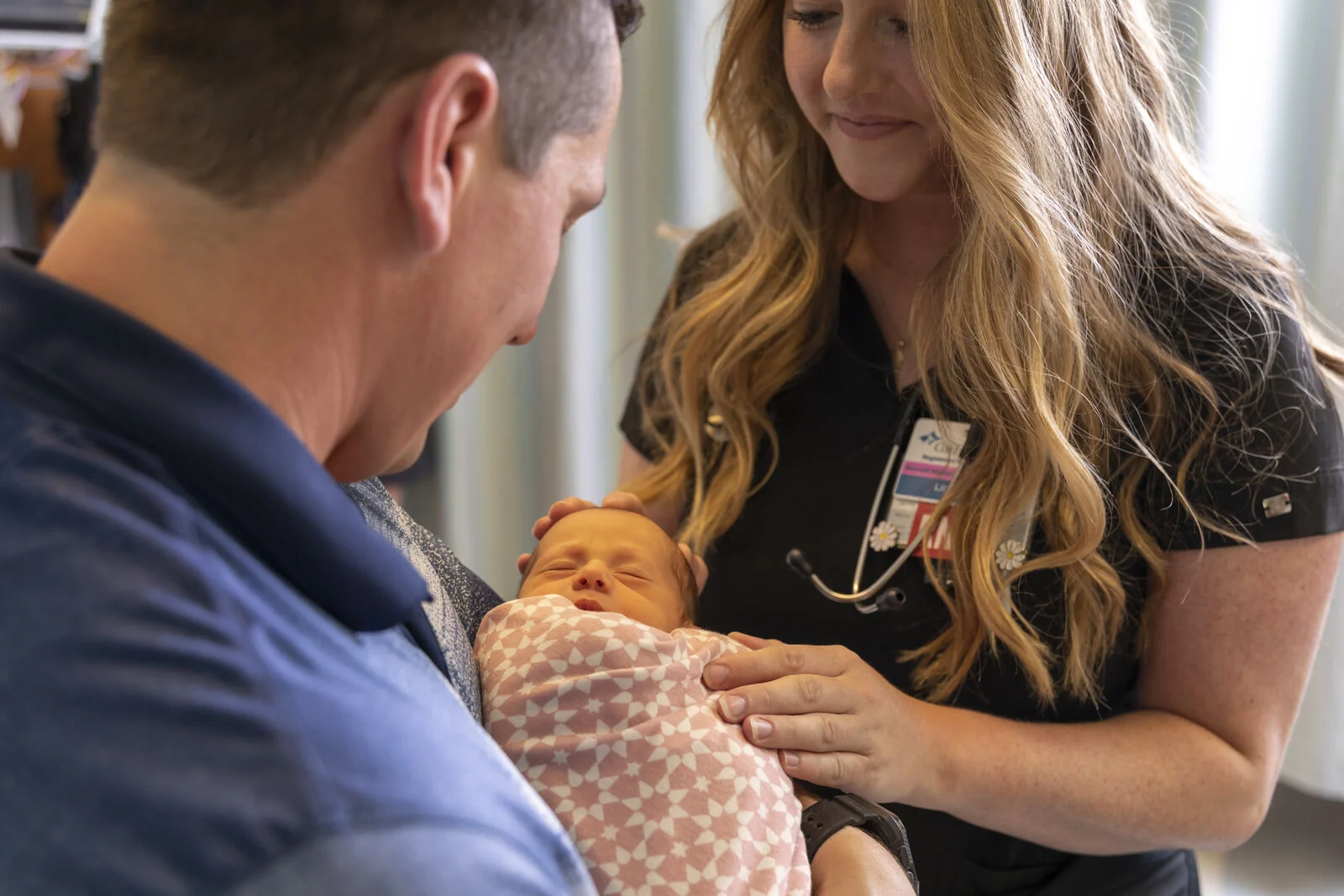 Two people holding a baby.