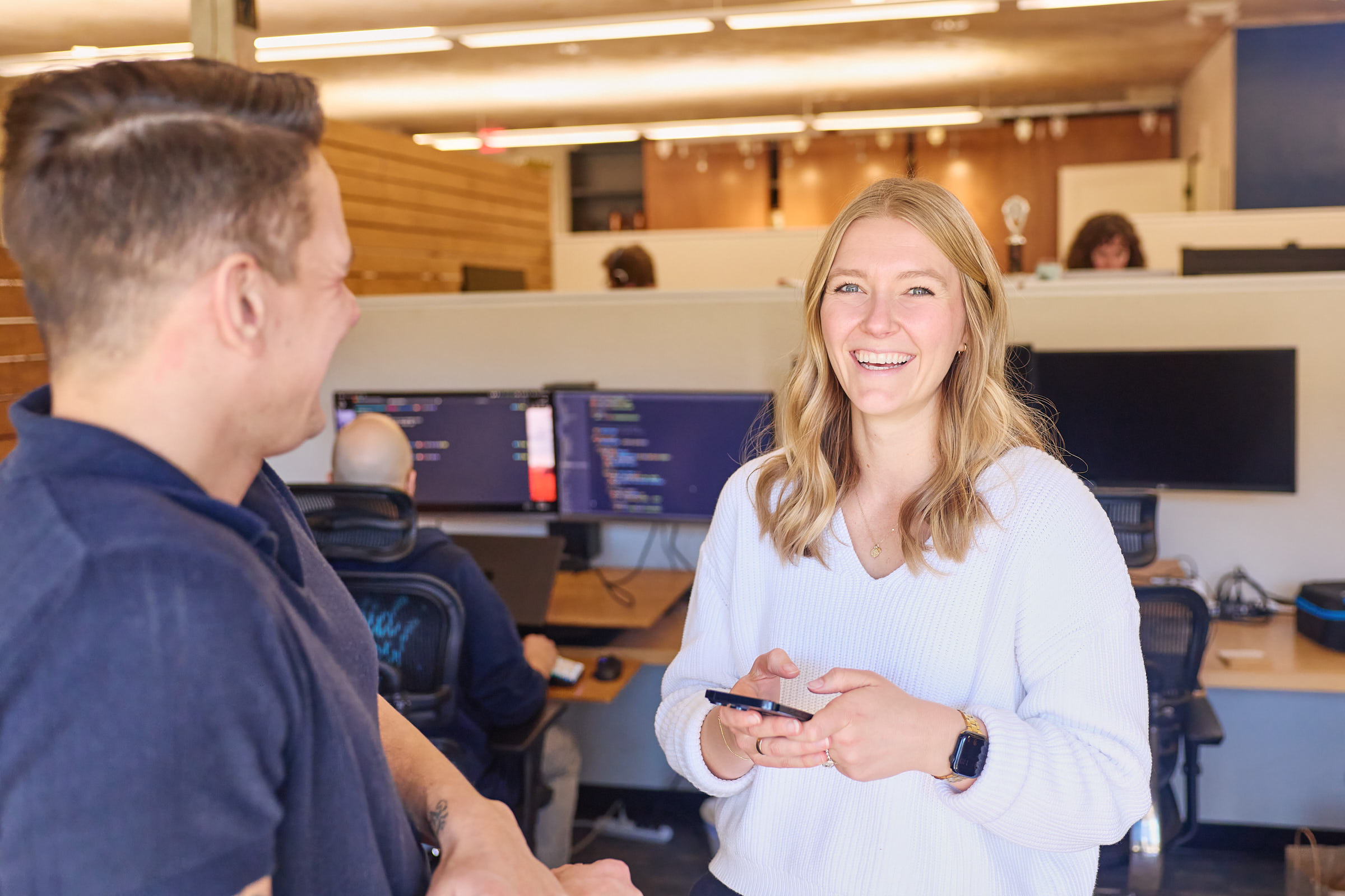 Two Mostly Serious team members talking in the office.