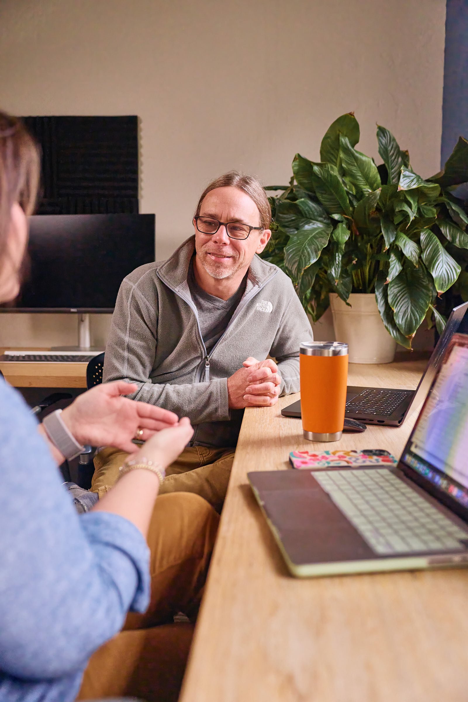 Two Mostly Serious team members discussing their work in the office.