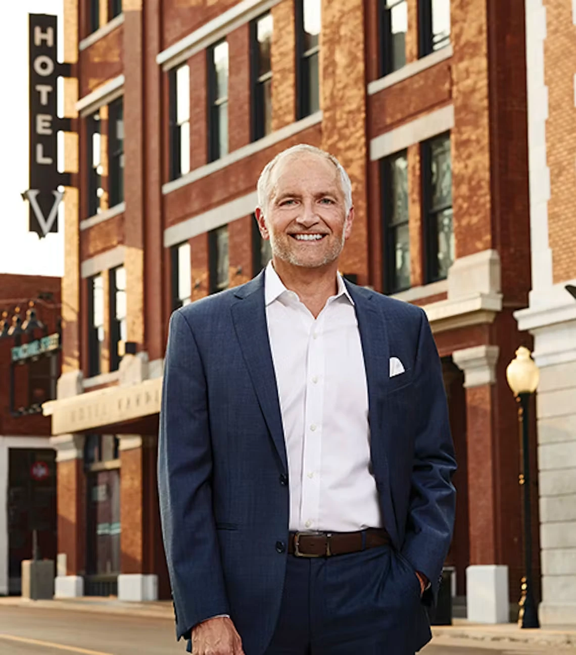 A man in a suit standing outside Hotel Vandivort.